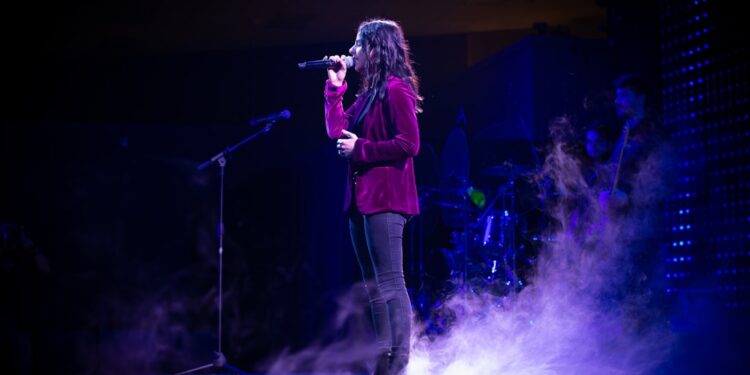 Female singer on stage with fog all around from a fog machine.
