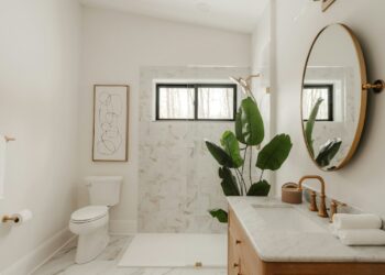 Modern bathroom with marble accents and a large plant.