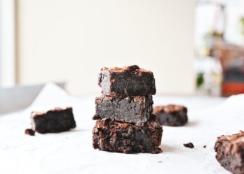 Stack of homemade brownies on parchment paper