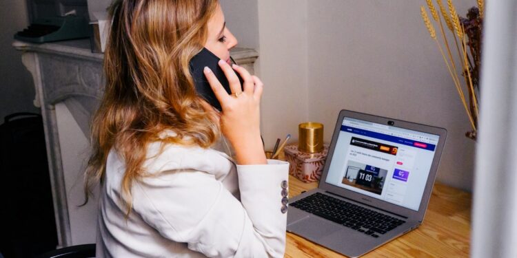 Vrouw aan een bureau met laptop en telefoon