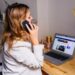 Vrouw aan een bureau met laptop en telefoon