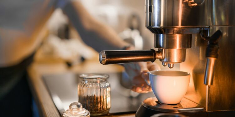 Koffiezetapparaat met glazen kan en een fles ontkalker op het aanrecht