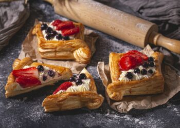 Plaattaart van bladerdeeg met kaas op een bakplaat