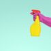 Sprayfles met schoonmaakazijn naast een glazen douchewand met kalkvlekken