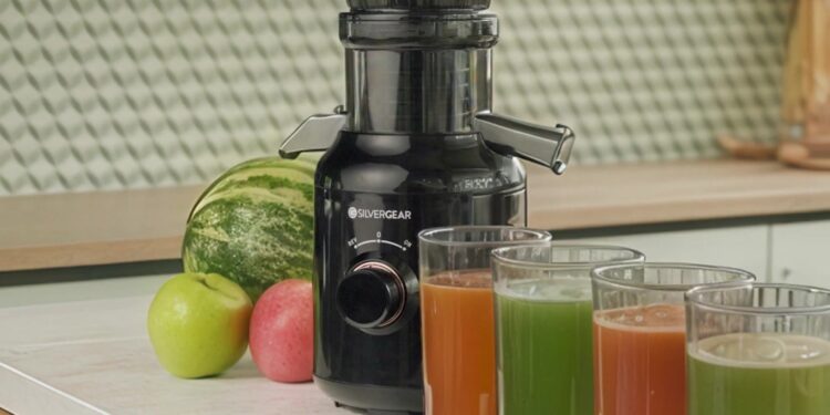 Zwarte Silvergear slowjuicer op een aanrecht met fruit en glazen vers sap