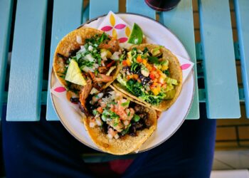 Zachte taco's gevuld met gekruid varkensvlees, zure room en een frisse salsa