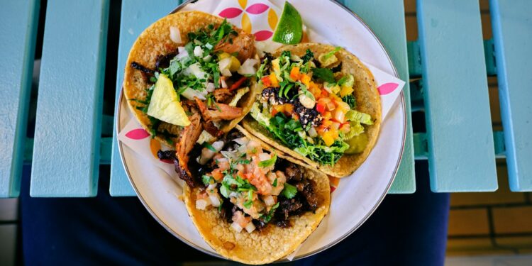 Zachte taco's gevuld met gekruid varkensvlees, zure room en een frisse salsa
