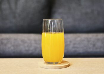 Glas verse wortelsap met wortels op een keukentafel