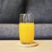 Glas verse wortelsap met wortels op een keukentafel