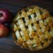 Appeltaart met een gevlochten deegrooster en karamel die langs de rand druipt