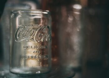 Pot augurken met augurkenvocht naast een glas cola