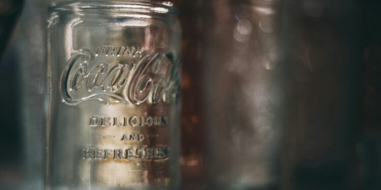 Pot augurken met augurkenvocht naast een glas cola