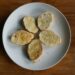 Crostini met gesmolten kaas, gekaramelliseerde ui en tijm op een plank
