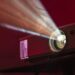 Projector die een film op een witte muur projecteert in een donkere woonkamer