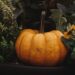 Oranje gietijzeren pan in de vorm van een pompoen op een gedekte herfsttafel
