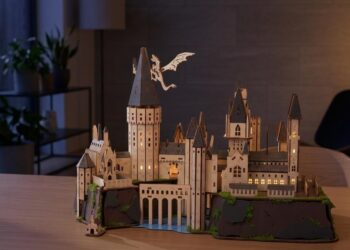 Houten 3D-puzzel van kasteel Zweinstein met verlichte ramen op een tafel