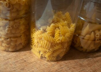 Keukenkast met pasta, rijst en blikken tomaten en bonen