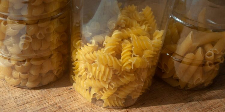 Keukenkast met pasta, rijst en blikken tomaten en bonen