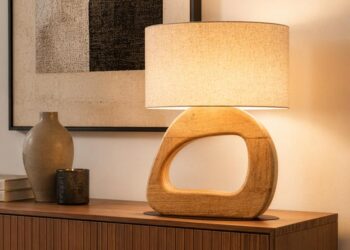 Mangohouten tafellamp met linnen kap op een houten dressoir naast een vaas
