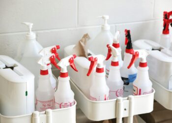 Emmer met schoonmaakspullen op een trap in een woning