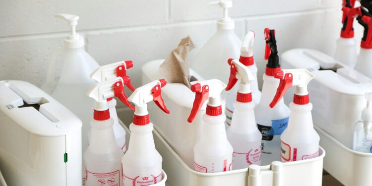 Emmer met schoonmaakspullen op een trap in een woning
