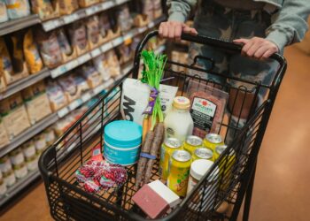 Boodschappenmand met verse producten in een supermarktgang