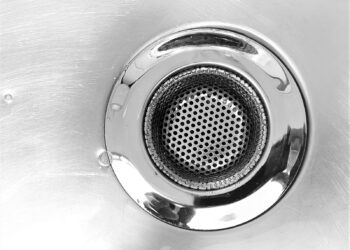 Afvoerputje in een gootsteen met water dat langzaam wegloopt