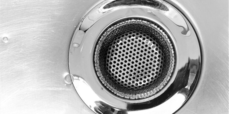 Afvoerputje in een gootsteen met water dat langzaam wegloopt