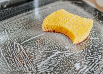 Schone ovenplaat op het aanrecht naast handschoenen en een sopdoek