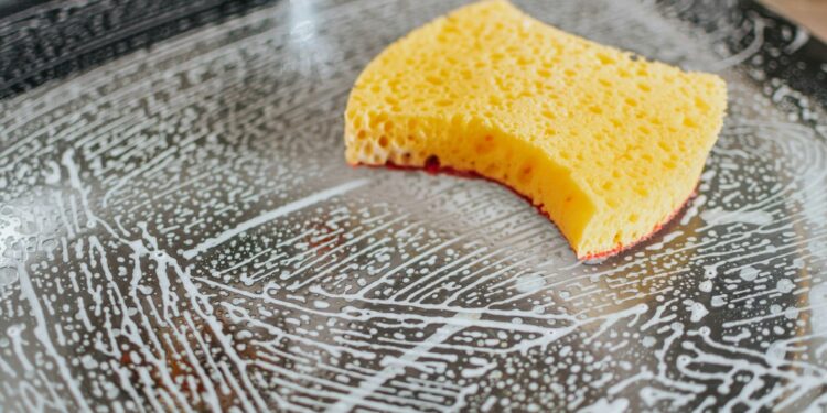 Schone ovenplaat op het aanrecht naast handschoenen en een sopdoek