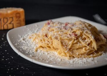 Bord spaghetti carbonara met spek en zwarte peper