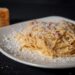 Bord spaghetti carbonara met spek en zwarte peper