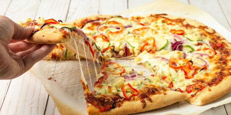 Versgebakken pizza met krokante bodem op een snijplank in een lichte keuken