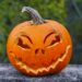 Uitgeholde Halloweenpompoen met gesneden gezicht op een stoep