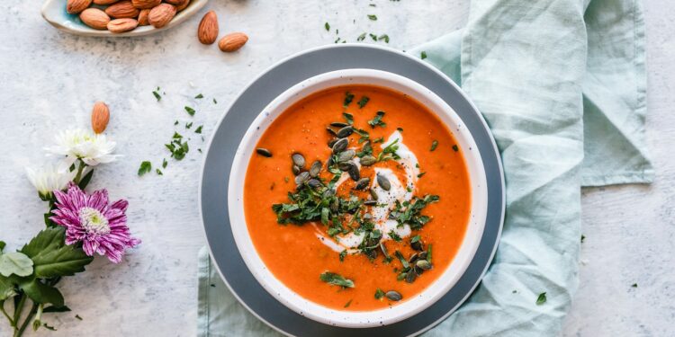 Kom oranje pompoensoep op tafel