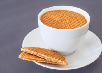 Stapel stroopwafels naast een kop koffie op tafel