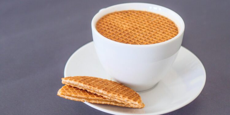 Stapel stroopwafels naast een kop koffie op tafel