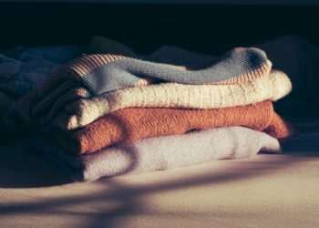 Opgevouwen zwart en grijs thermo-ondergoed op een bed