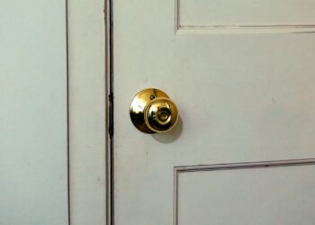Stoffen tochtstopper op de vloer tegen de onderkant van een voordeur